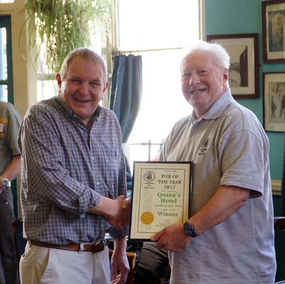 Gary Owen, landlord of The Queen's Hotel, receives the Swansea Camra Pub of the Year award from chairman Paul James, right.